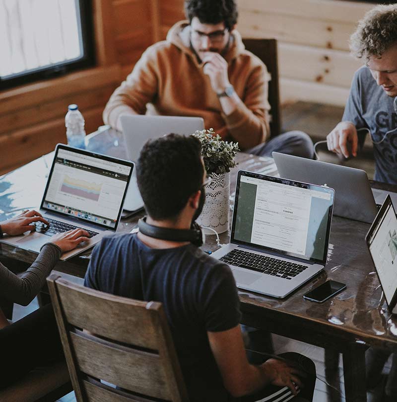 Co-workers using laptops on table